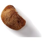 een stuk brood bovenop een wit oppervlak.
