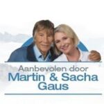 Twee mensen, een oudere man en een jongere vrouw, die glimlachen terwijl ze hun armen om elkaar heen hebben geslagen. De Nederlandse tekst luidt: "Aanbevolen door Martin & Sacha Gaus.